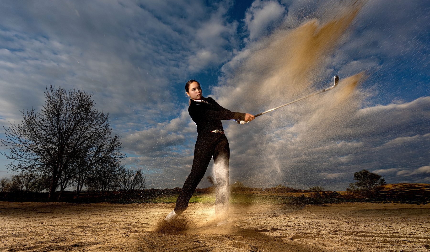 Mid-action, sand spray on the golf course